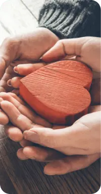 Hands holding a wooden heart